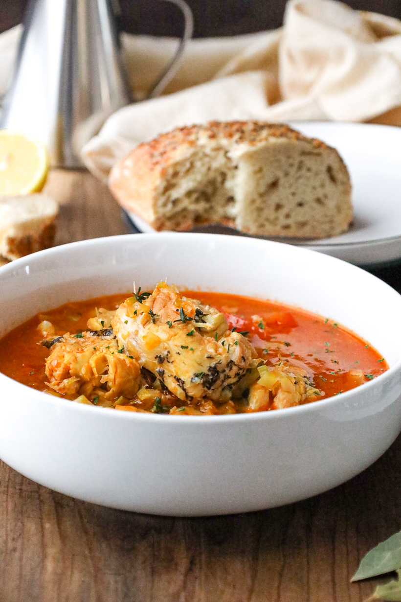 bouillabaisse fish stew in white bowl with bread