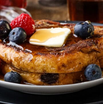 syrup, butter, and fruits on top of brioche French toast