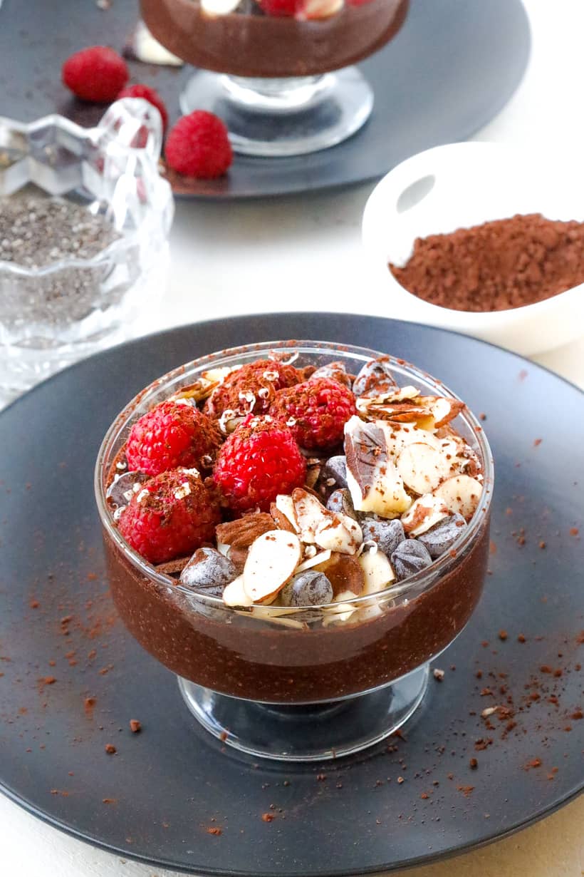 pudding with fruits on black plate and chia seed in the back