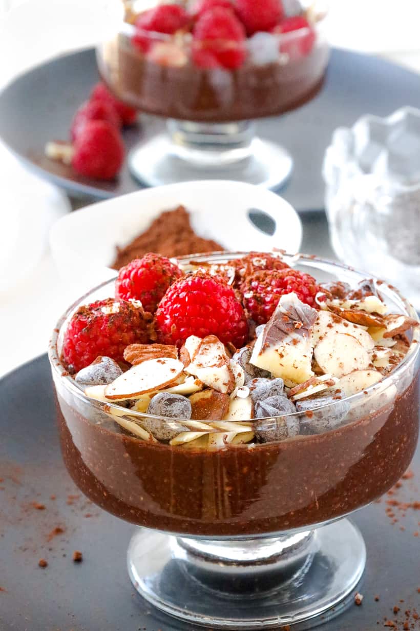 chocolate chia seed pudding on black plate with fruits