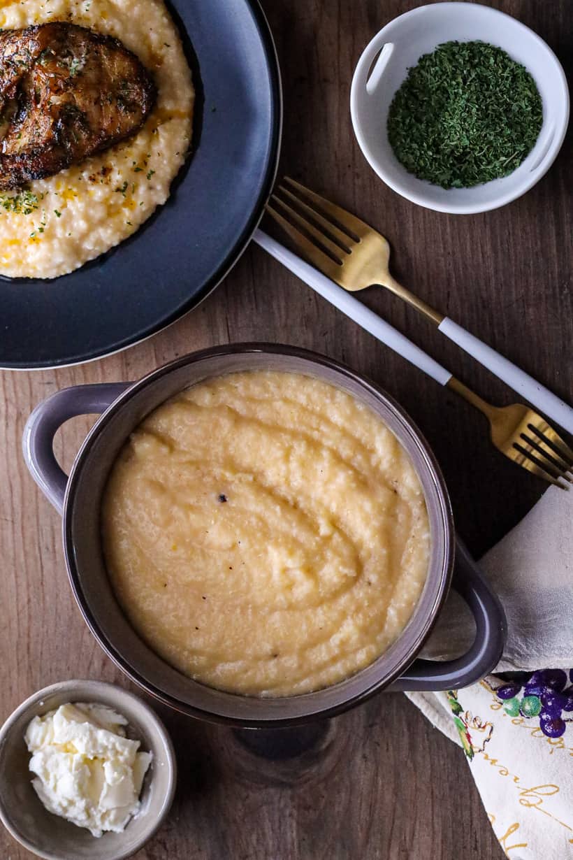 Grits in brown bowl on wooden board