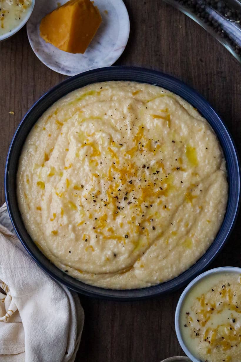 cheese grits with cheddar topped with cheese in blue bowl