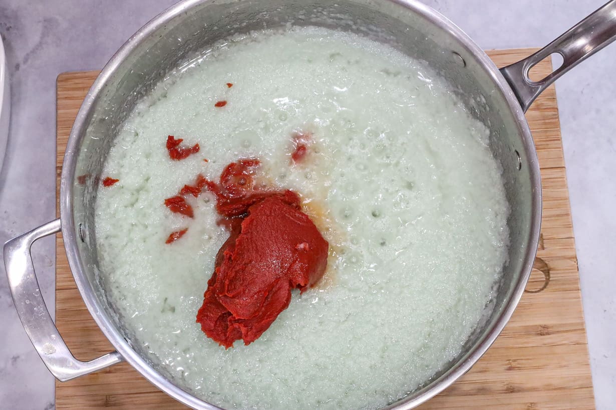 onions and tomato paste in saucepan