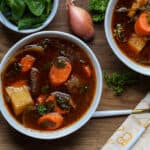 haitian bouillon in two white plate on wooden board