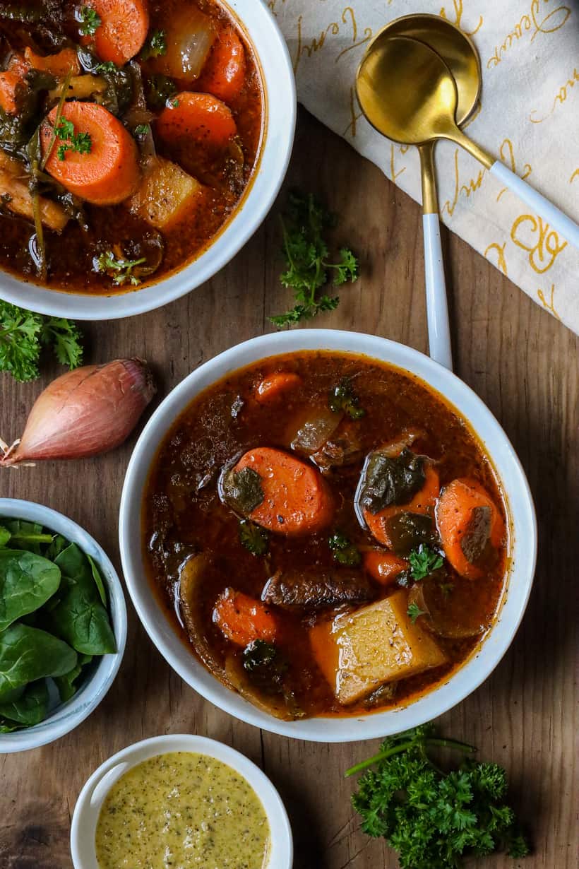 haitian bouillon in two white plate on wooden board