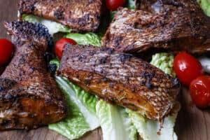 air fried porgy fish on a bed of lettuce and tomatoes