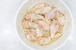 wings in white bowl marinating