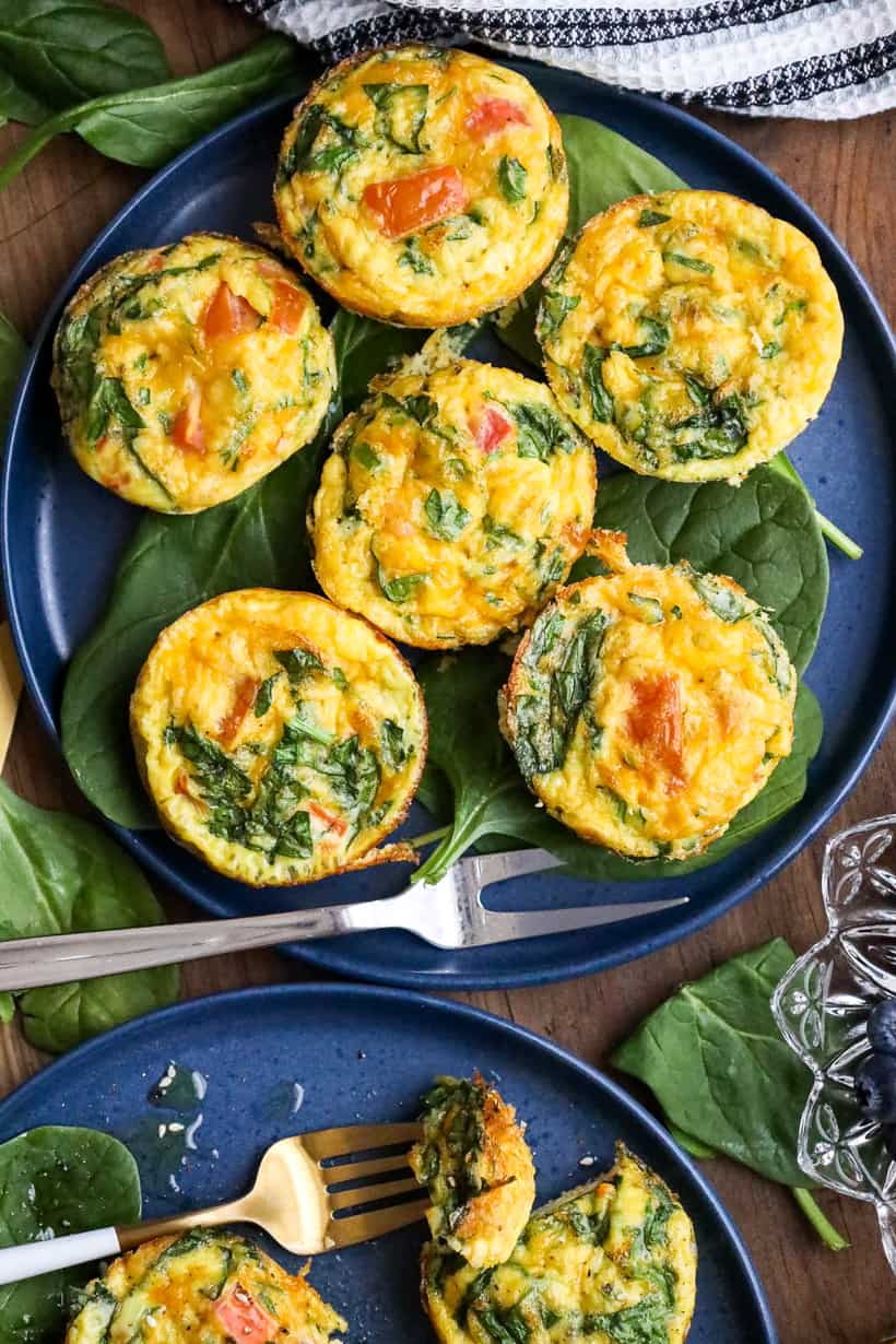 breakfast egg muffins on a bed of spinach on blue plate