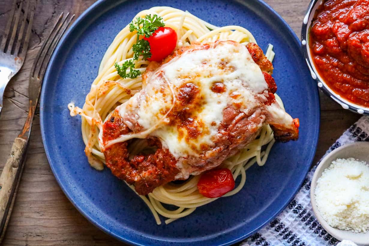 parmesan chicken on blue plate with pasta