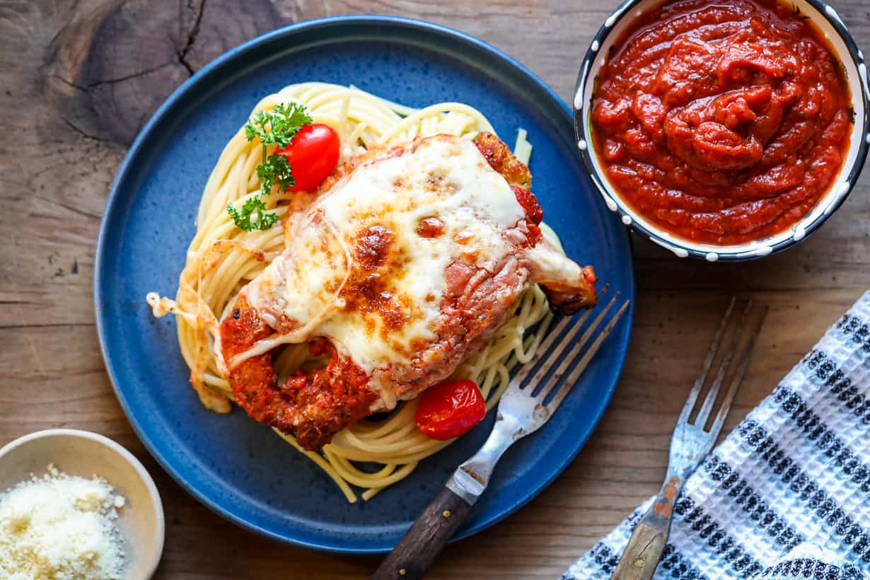 chicken parmesan on blue plate with pasta