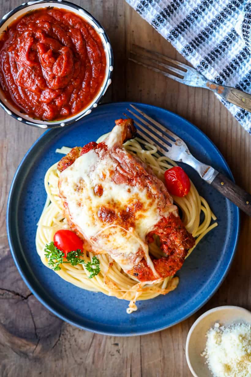 chicken parmesan on blue plate with pasta