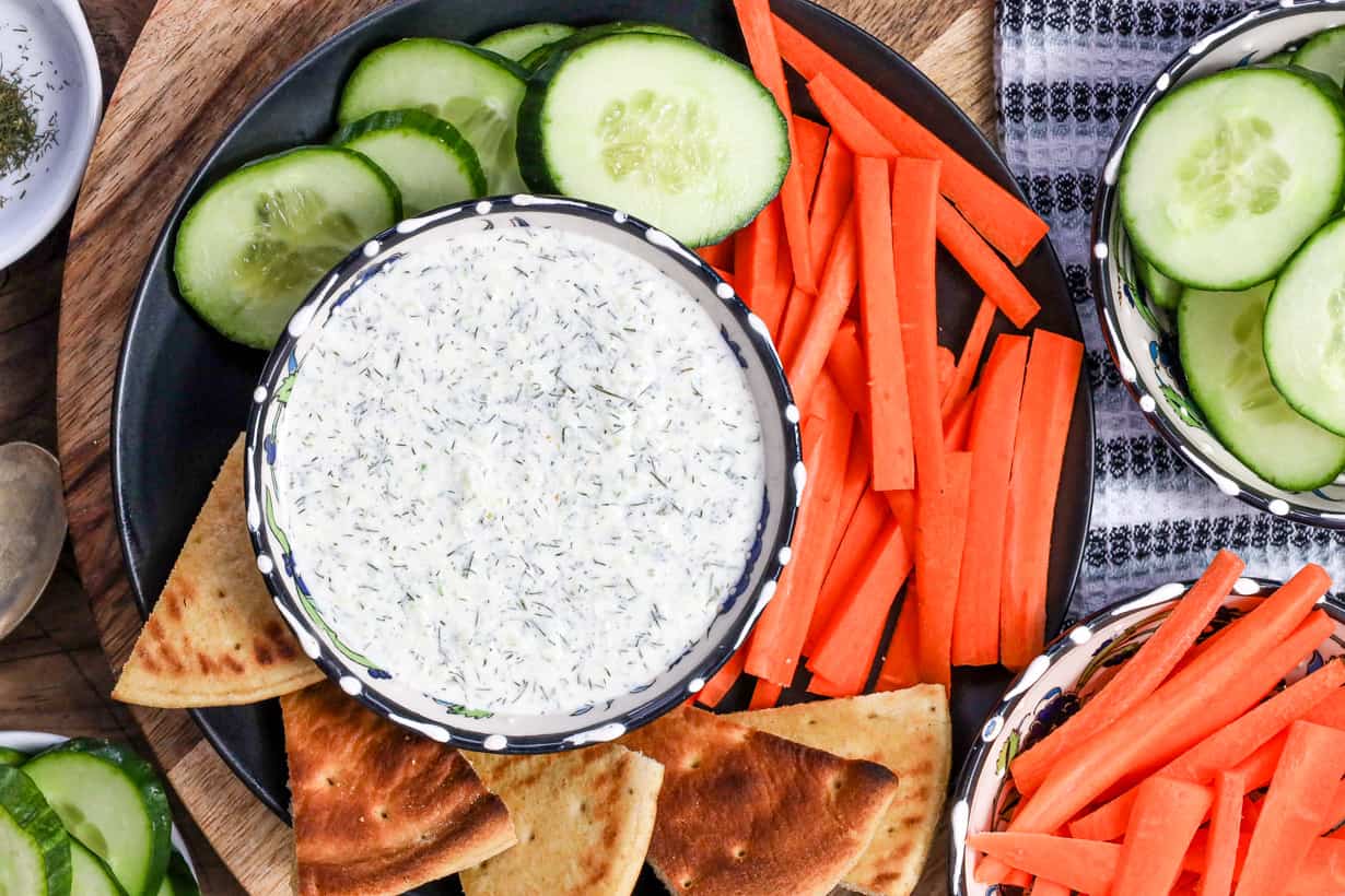 tzatziki dip in bowl on black plate