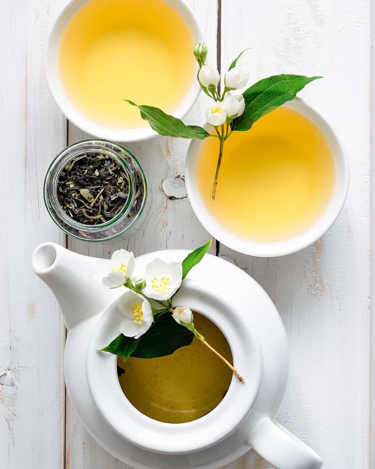 Tea in cups and kettle on white background