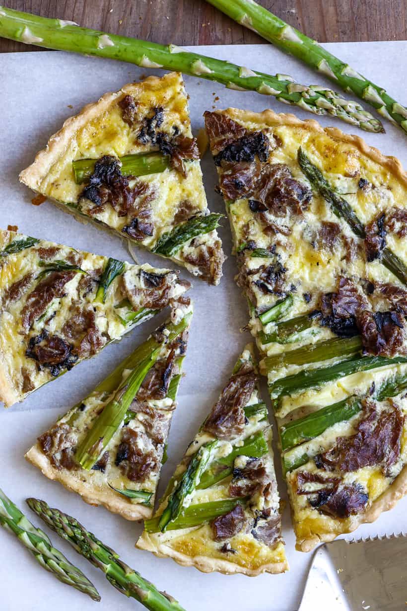 Cooked asparagus tart on paper and wooden bard