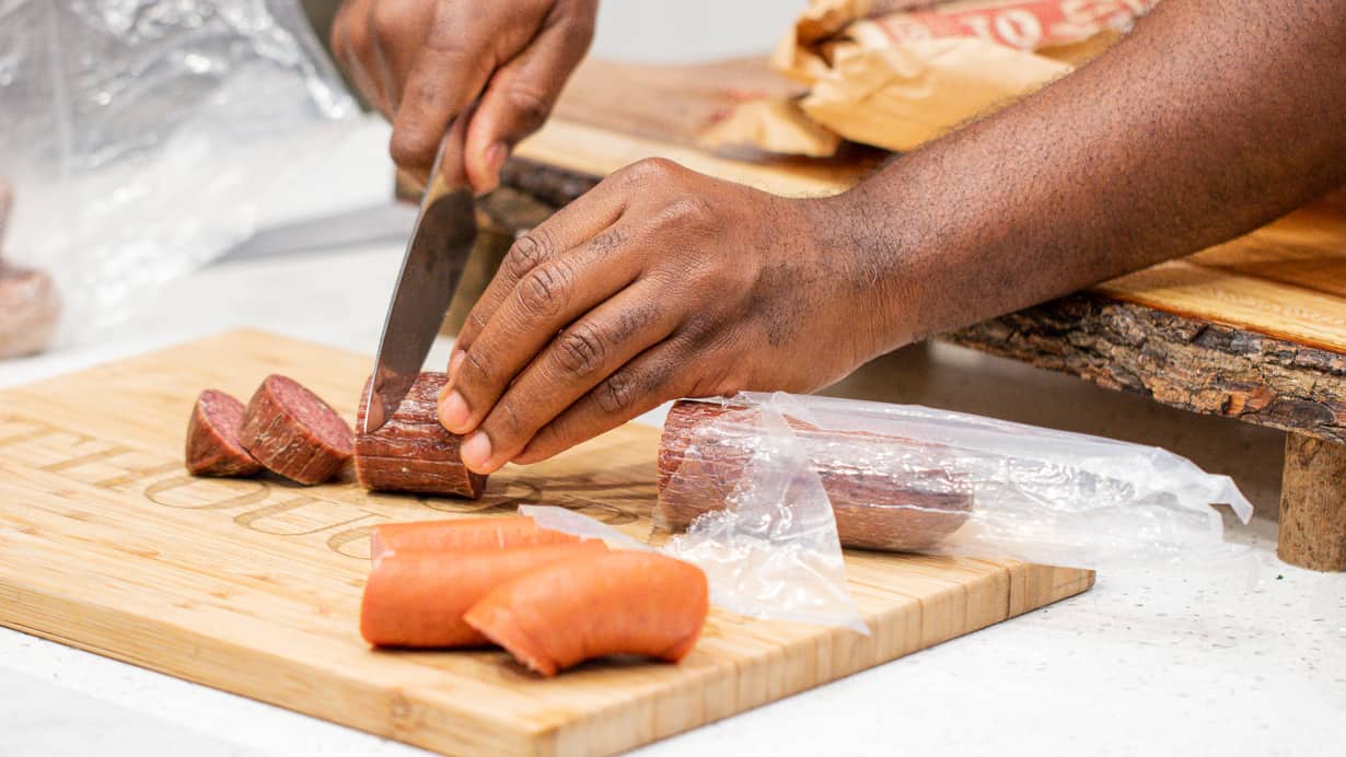 hand cutting sausage.