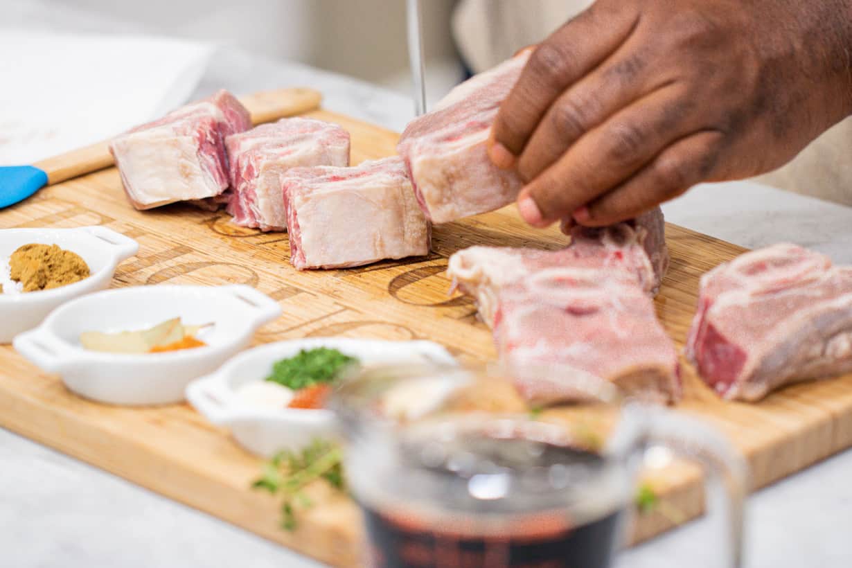 Hand cutting meat on a cutting board