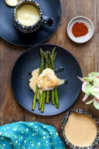 packed eggs with hollandaise sauce over asparagus