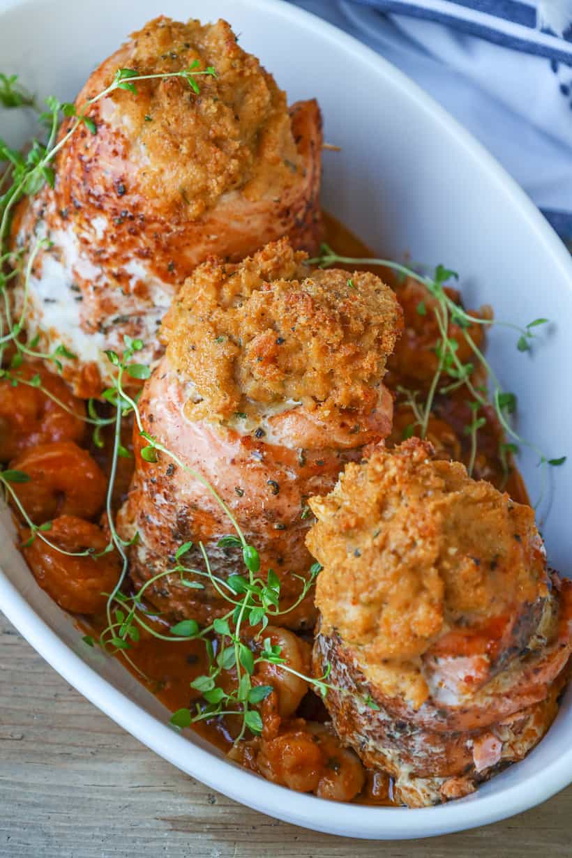3 salmon stuffed with shrimp in baking dish and herbs.