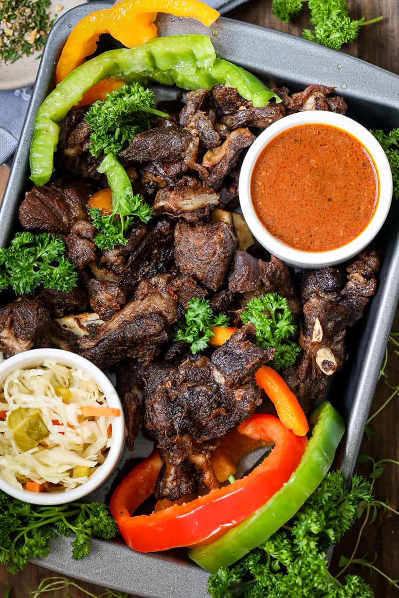 Fried Goat Meat with pikliz and sauce in baking dish