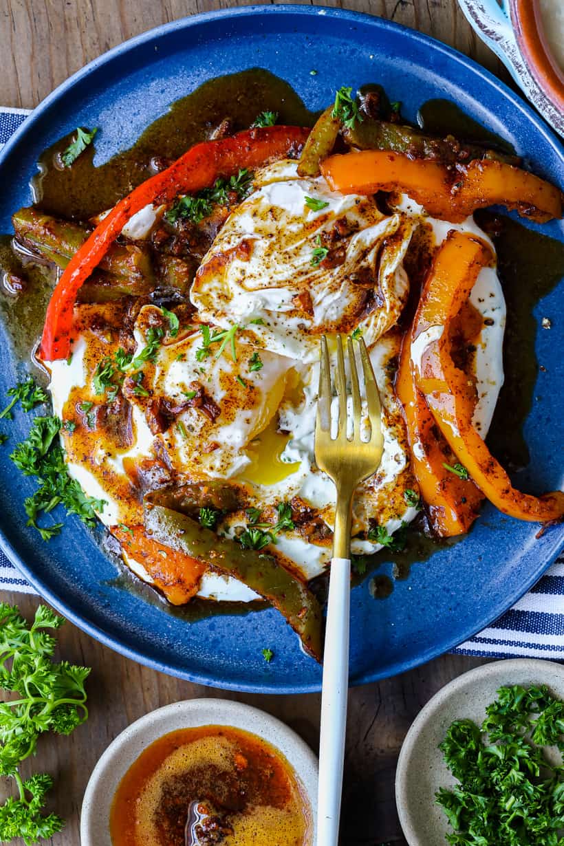 Turkish eggs with fork on blue plate