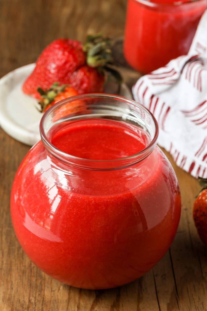 Strawberry coulis in jars with fresh fruits