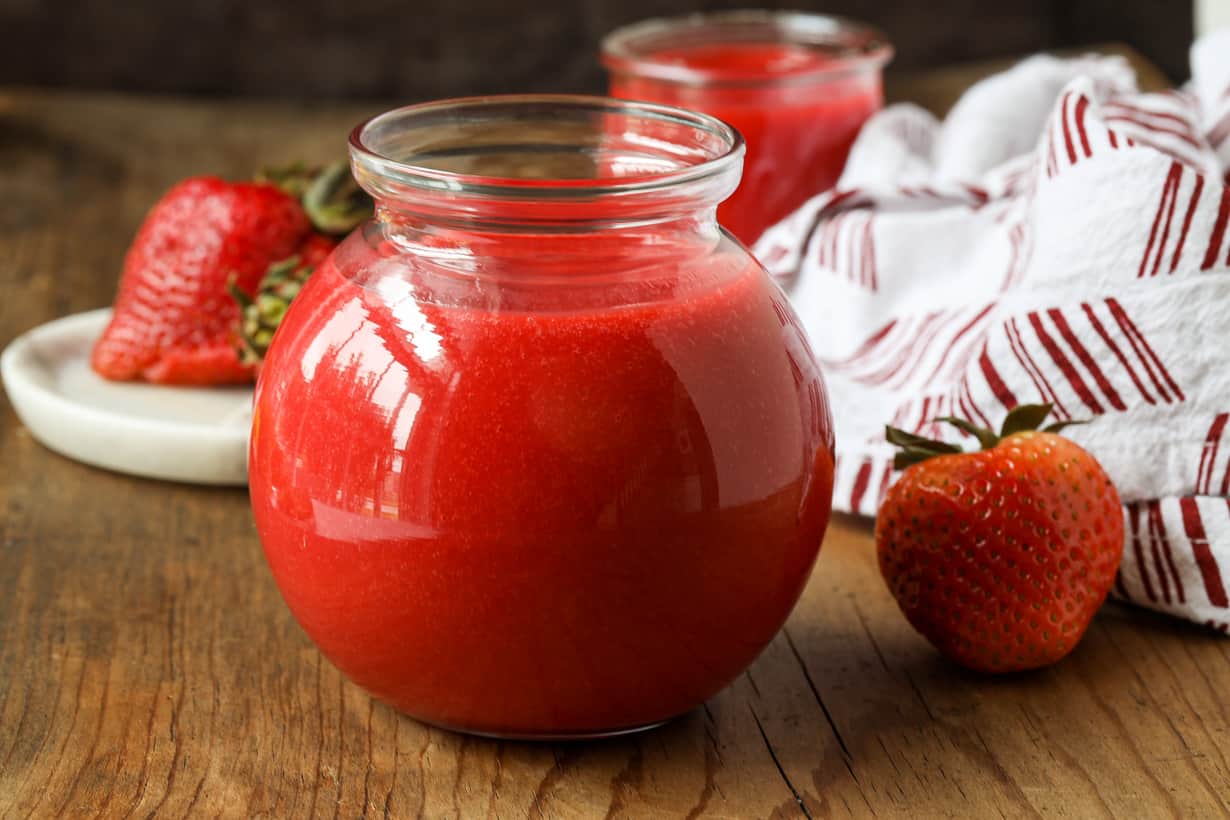 coulis with strawberries on wooden board