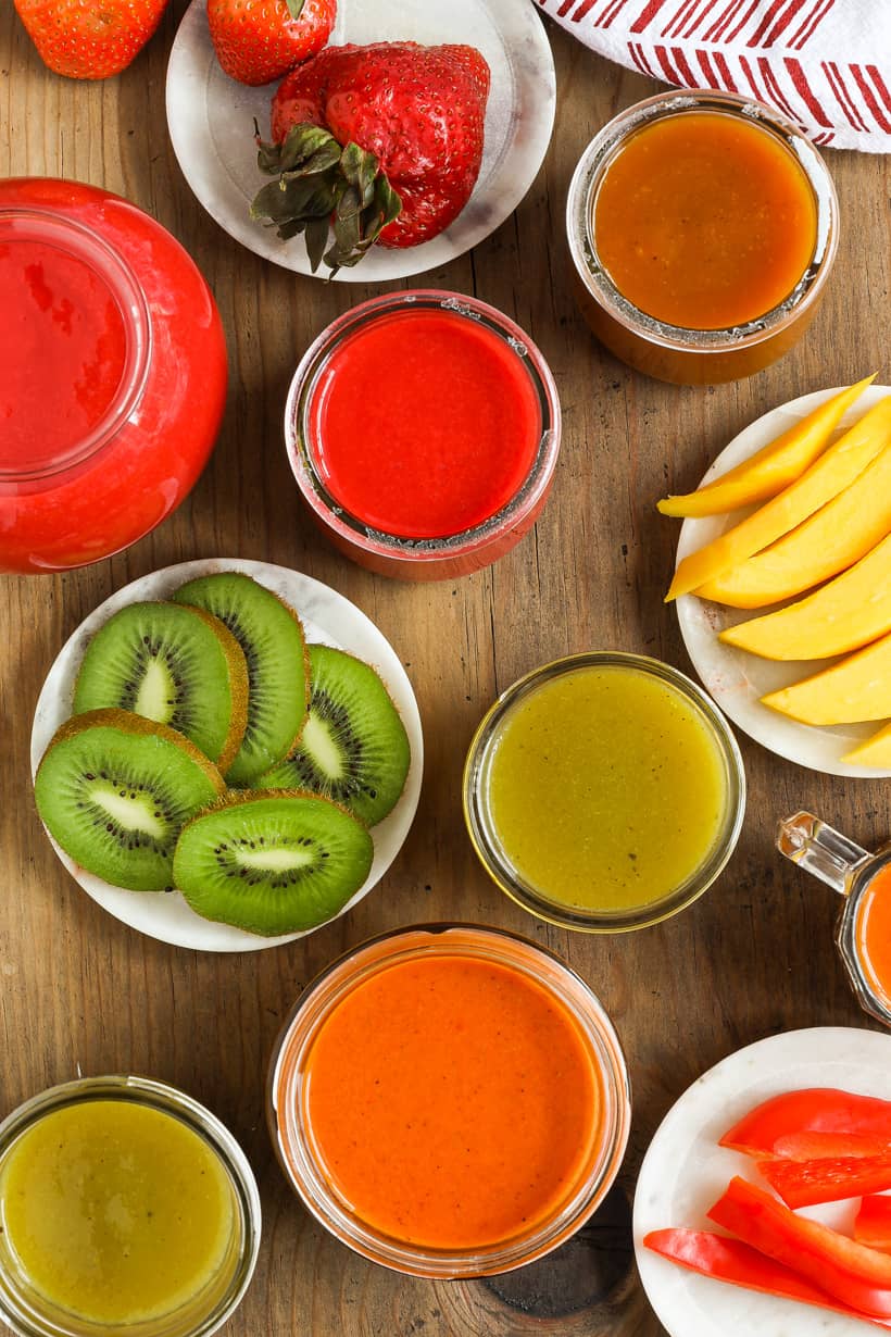 various coulis and fruits on wooden board