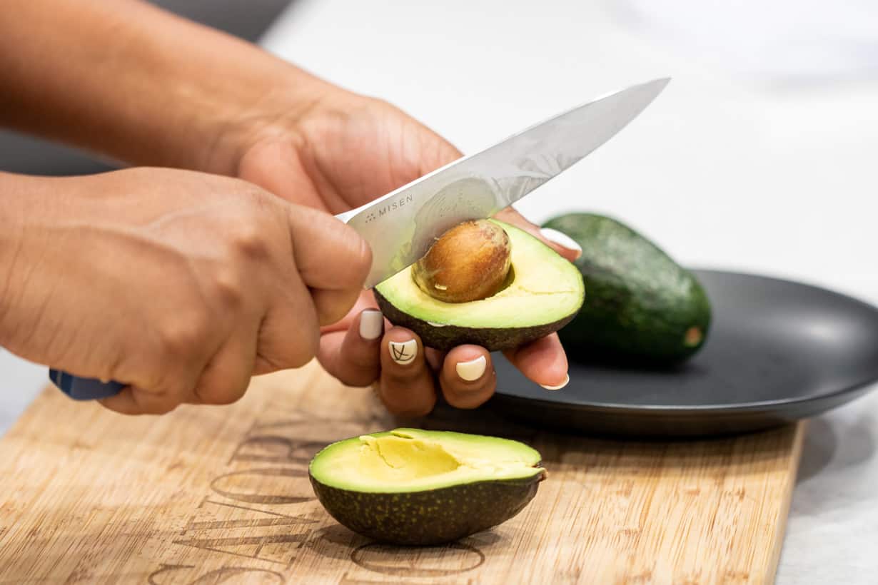 knife cutting on the seed of the avocado