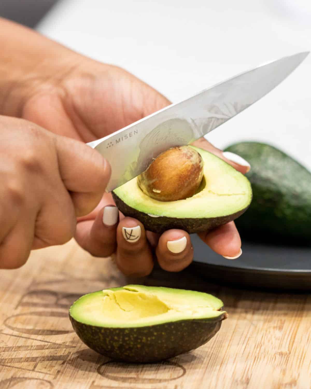 knife slicing seed from avocado