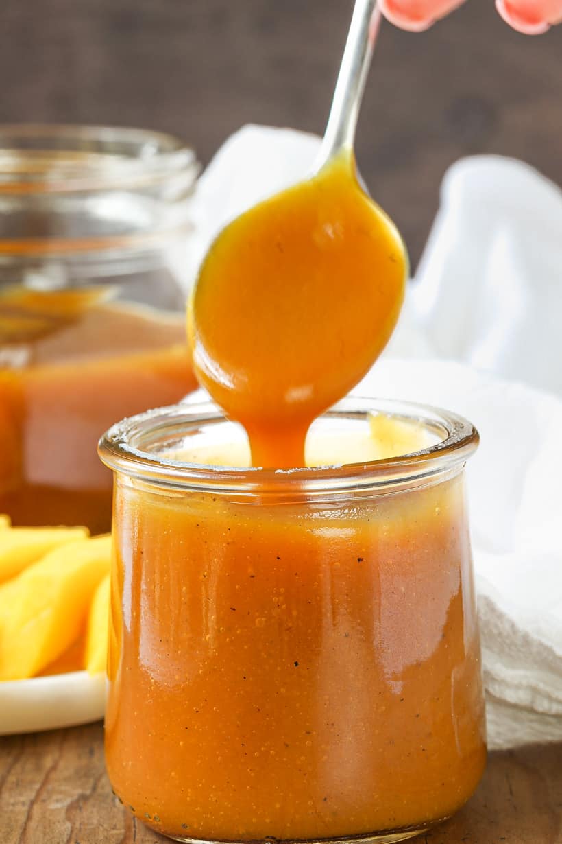 Spoon holding mango sauce