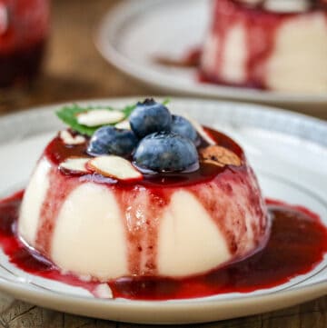 Panna Cotta on plate with shaved almond and blueberries