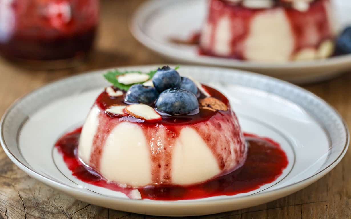 Panna Cotta on plate with shaved almond and blueberries