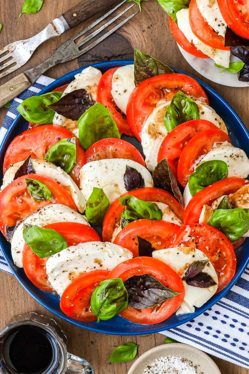 Delicious Caprese Salad Recipe on blue plate with wooden fork