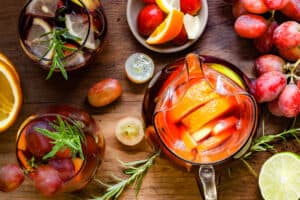 pitcher of sangria with glasses of sangria and grapes