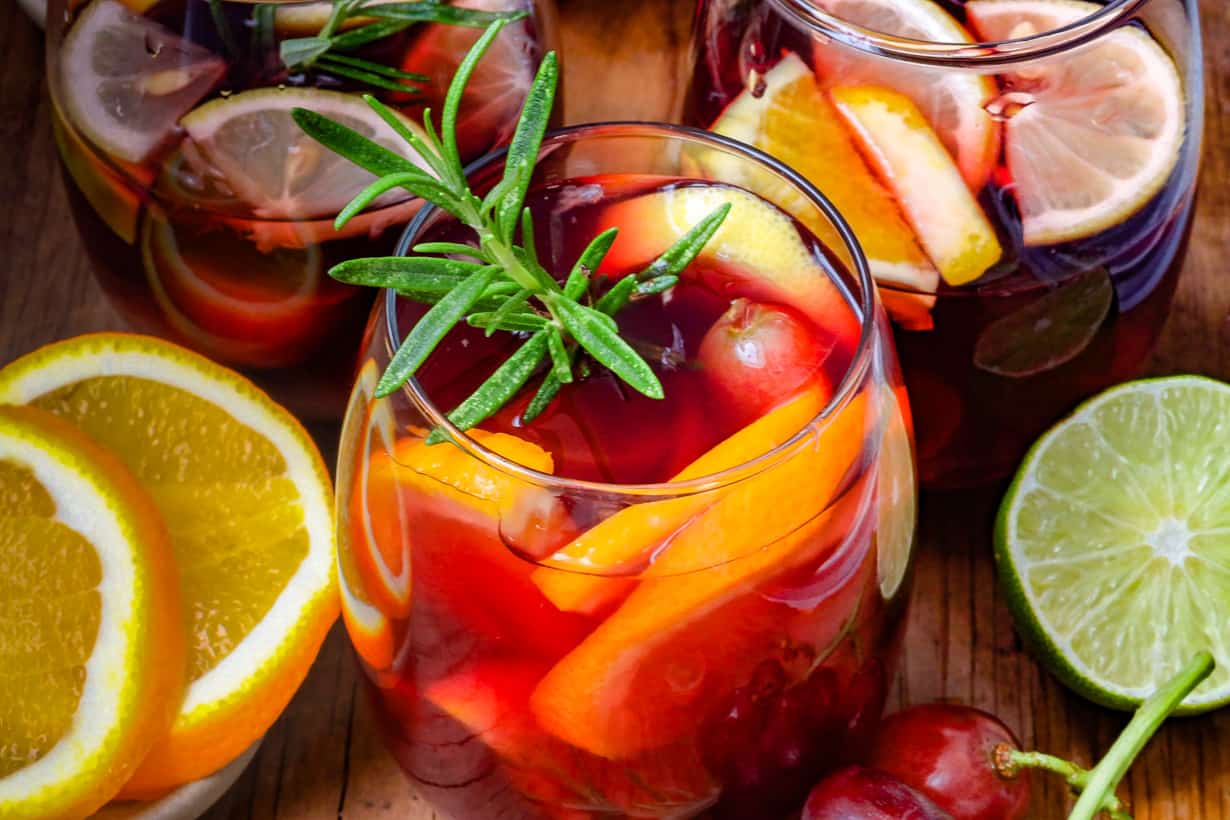 sangria in glass with fruits and rosemary stem, non-alcoholic
