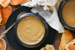 plantain porridge in black bowl with bread