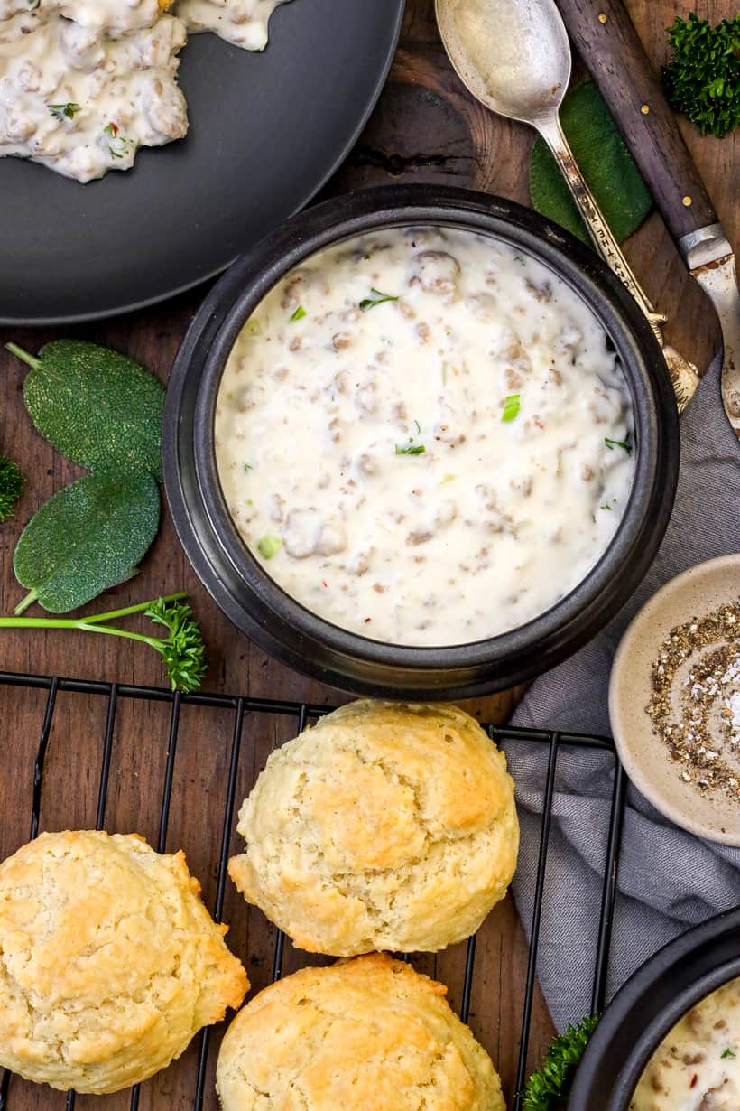 gravy in bowl with 3 biscuits on the side