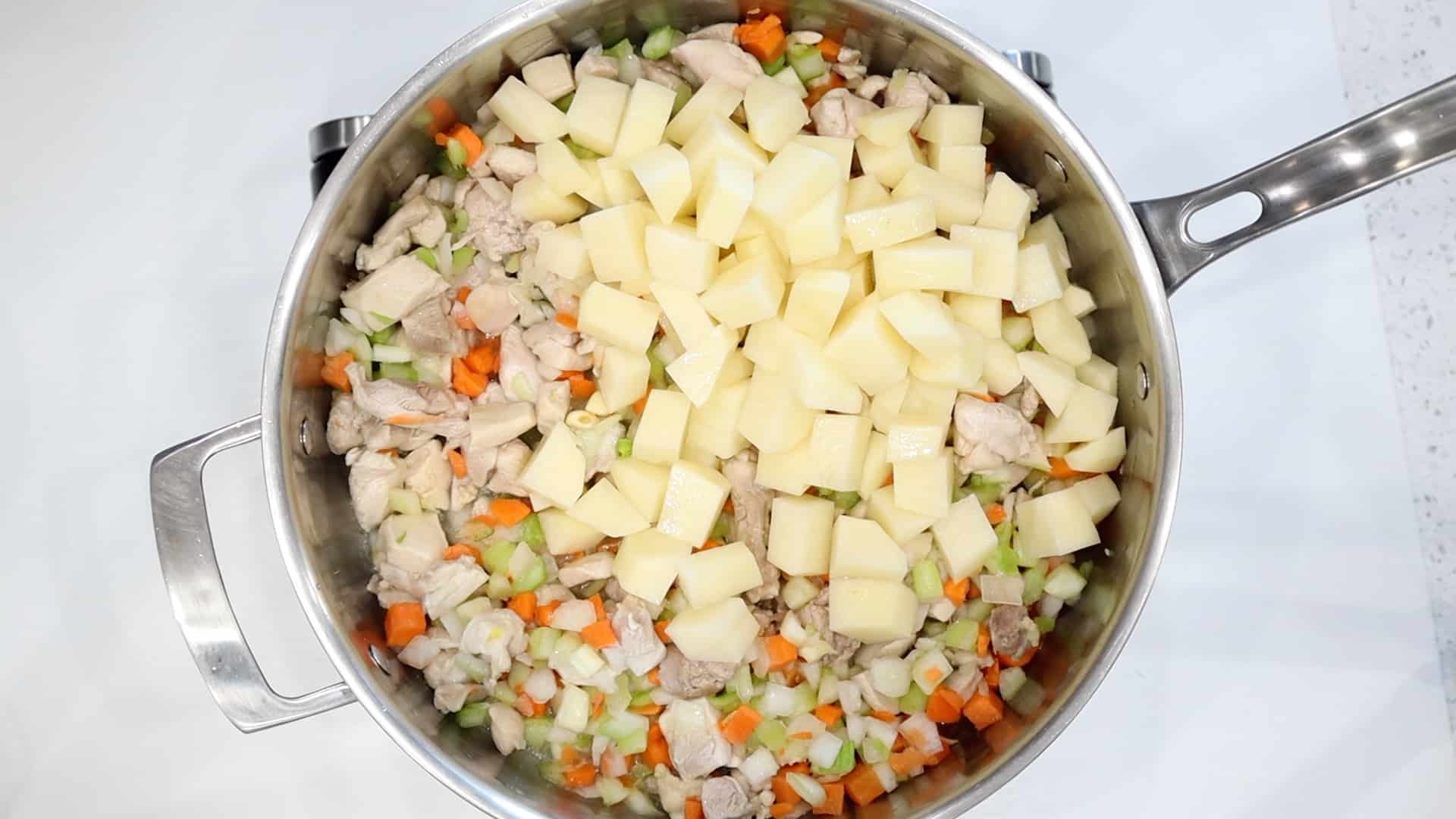 Adding potatoes and mire poix to chicken