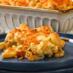 Mac and cheese with broccoli baked on blue plate with fork