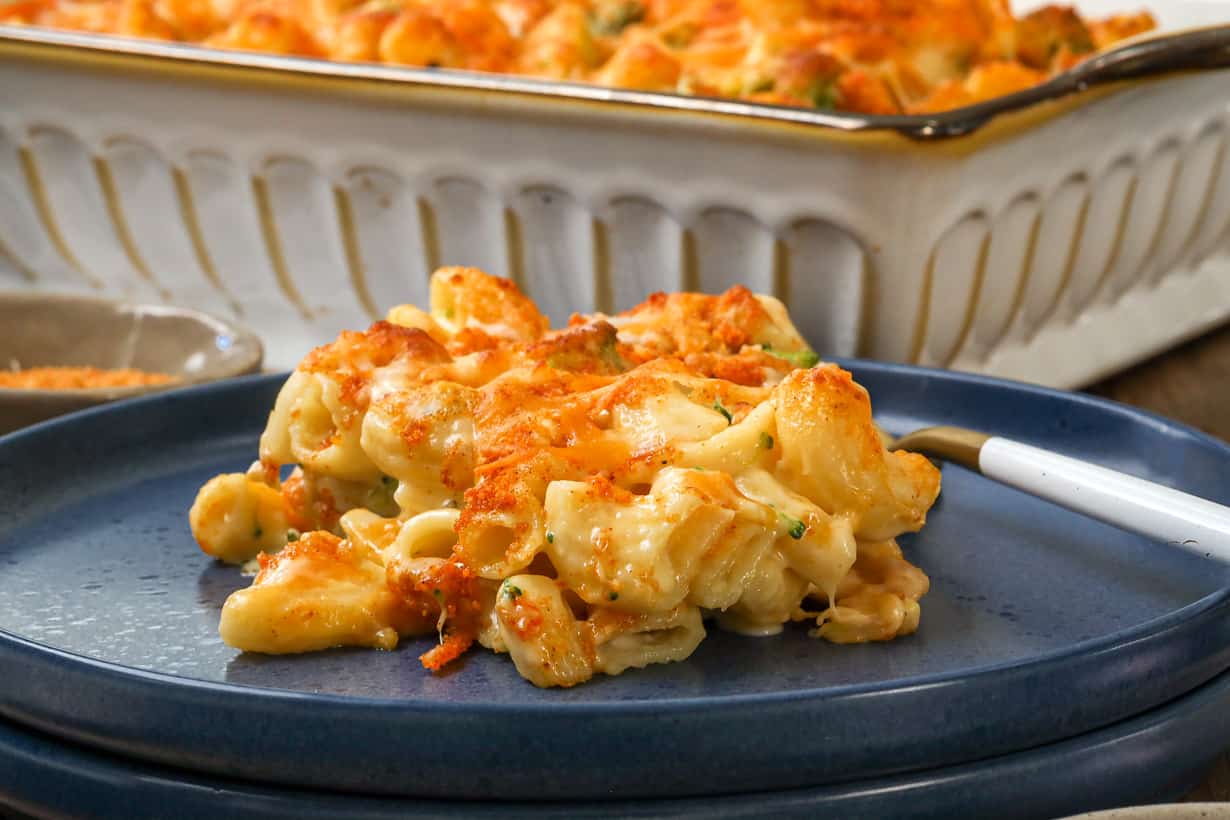 Mac and cheese with broccoli baked on blue plate with fork