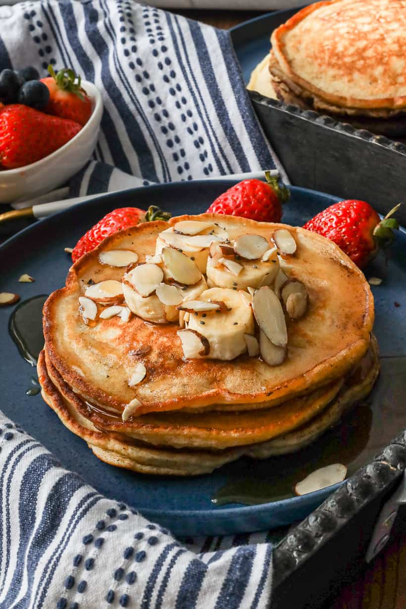 banana pancakes topped with sliced bananas, nuts, and chia seeds