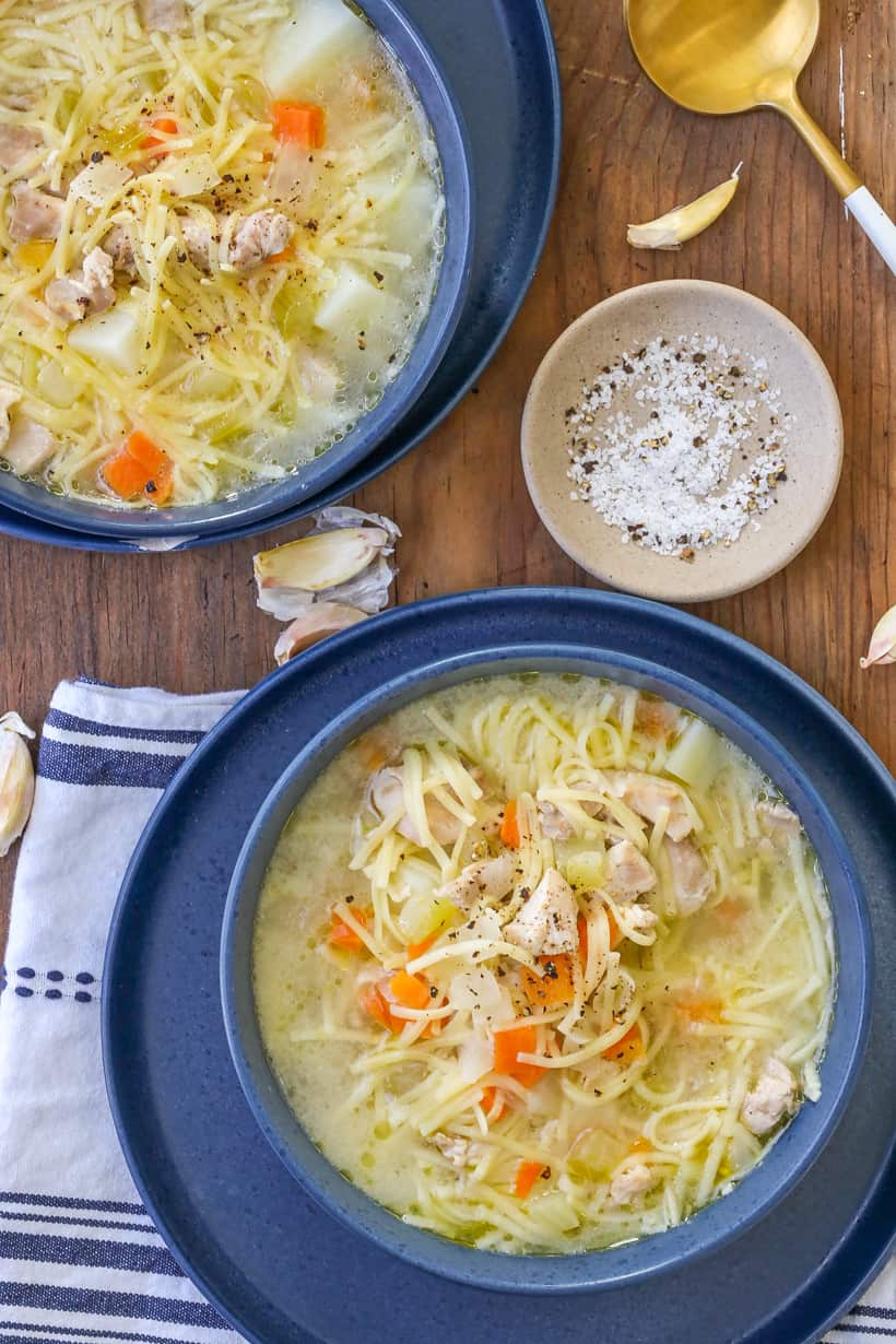 chicken broth soup in bowls with vegetables and noodles