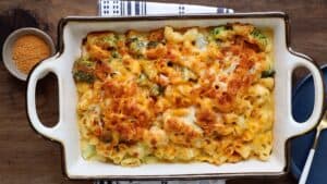 mac and cheese with broccoli in baking dish on wooden board