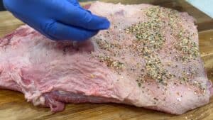 Adding seasoning to brisket