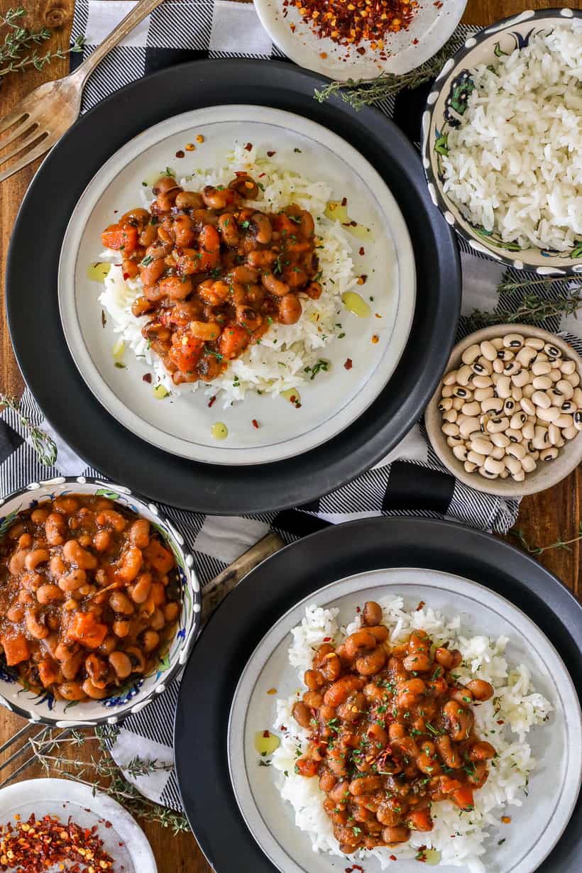 Two plates of black eyed peas over rice