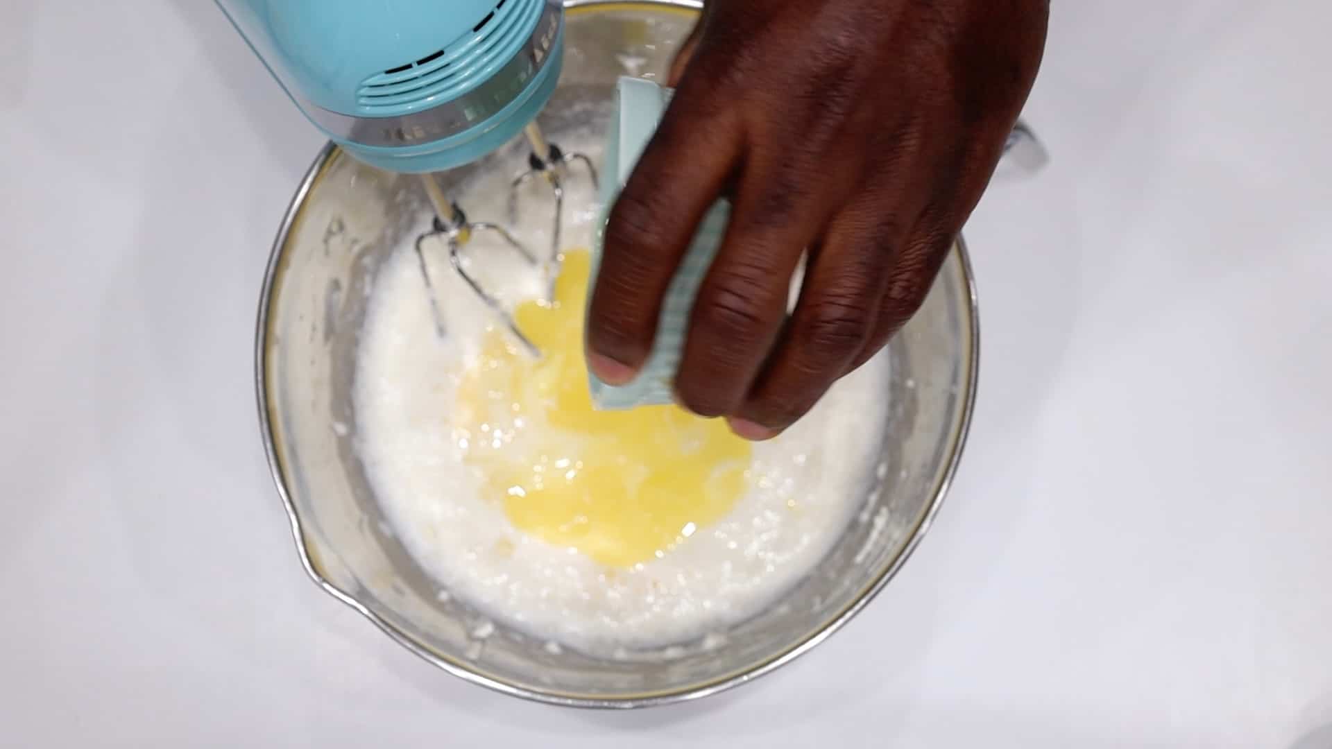 adding eggs to cream cheese
