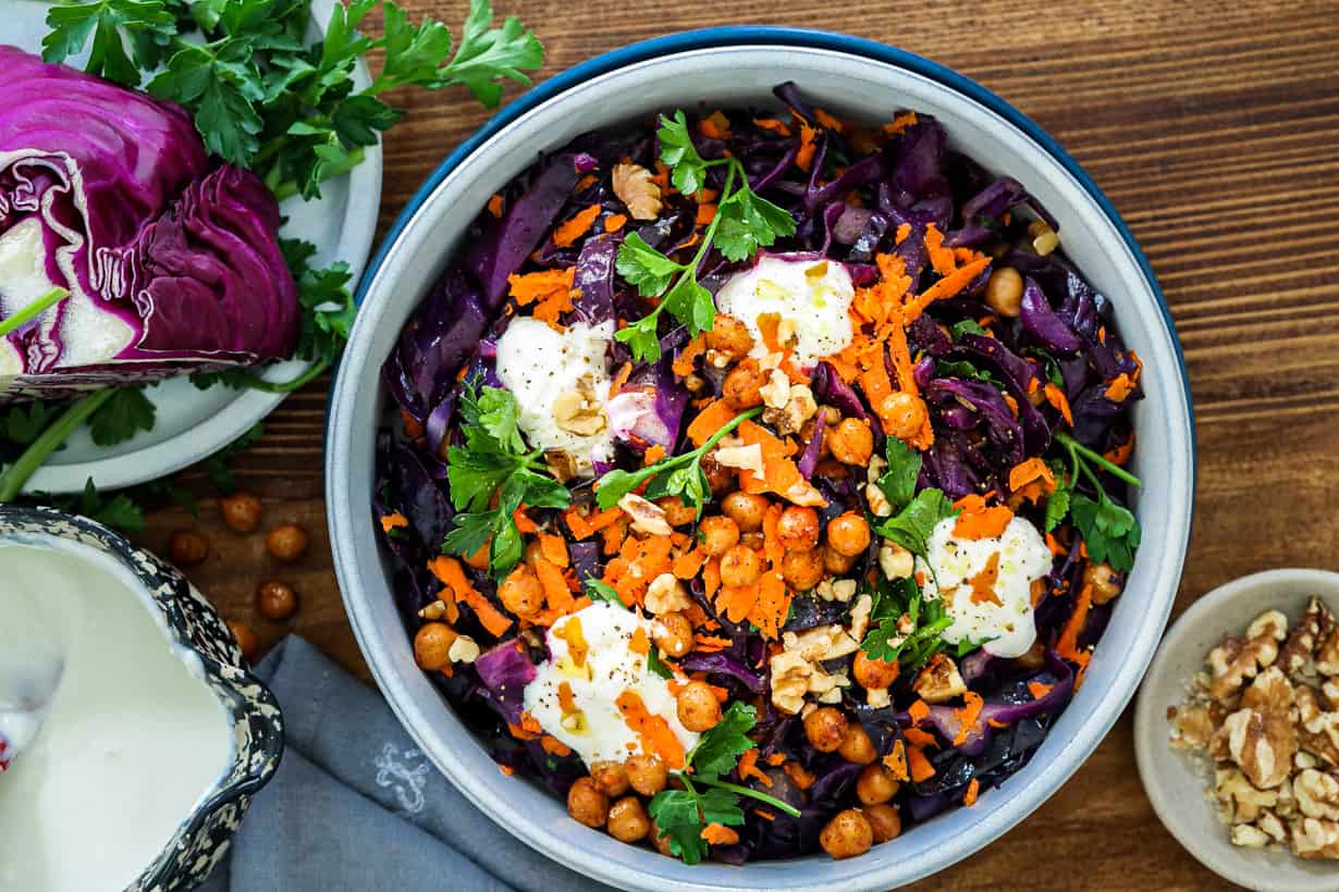 red cabbage salad in bowl topped with parsley and yogurt