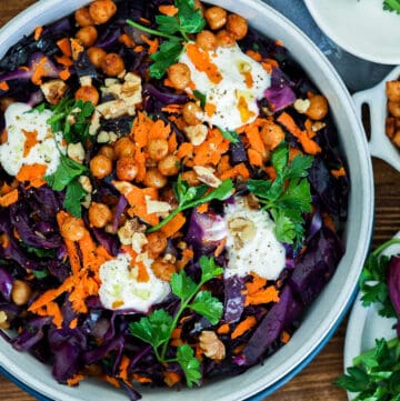 red cabbage salad in bowl topped with parsley and yogurt