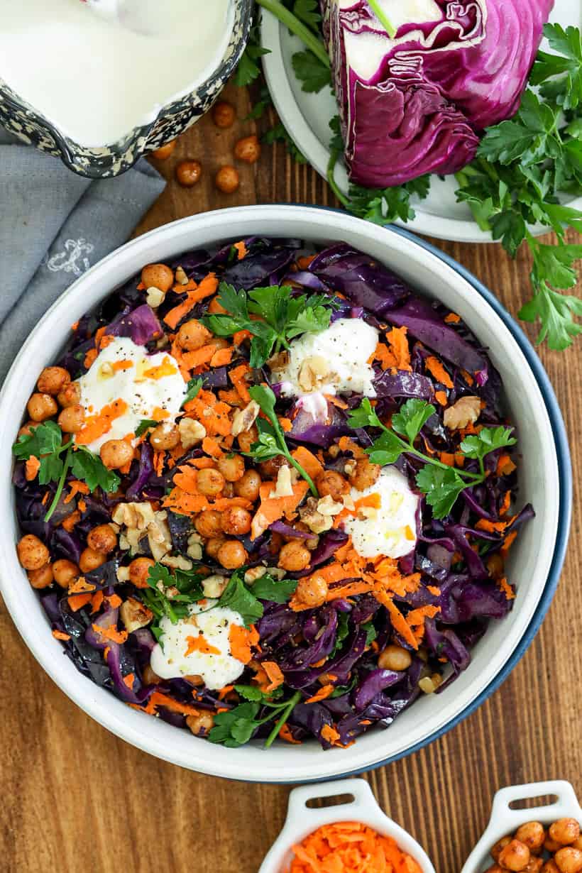 red cabbage salad in bowl topped with parsley and yogurt