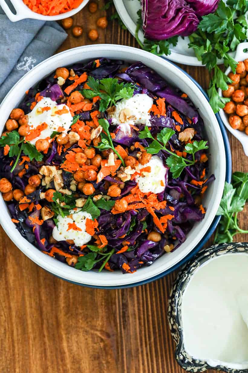 red cabbage salad in bowl topped with parsley and yogurt